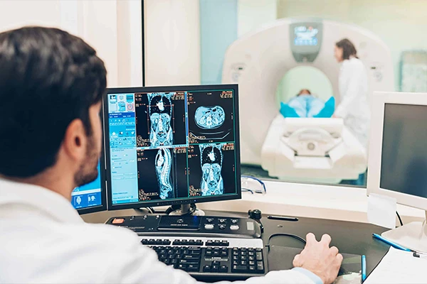 A technologist at a scanner console